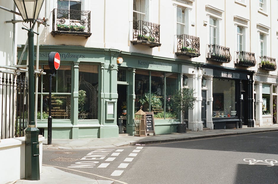 The image depicts a charming flower shop situated on Portobello Road in Notting Hill, London, operated by a local florist specializing in floral gift arrangements and flower delivery services. The sho